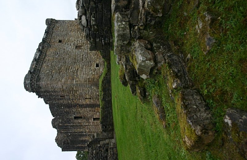The tower keep and ruins of a rampart tower from the northwest.