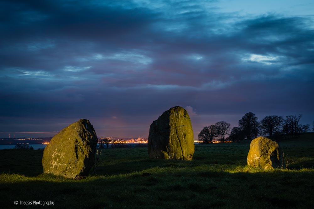 The three boulders at night with the lights of Grangemouth and Bo&apos;ness on the horizon