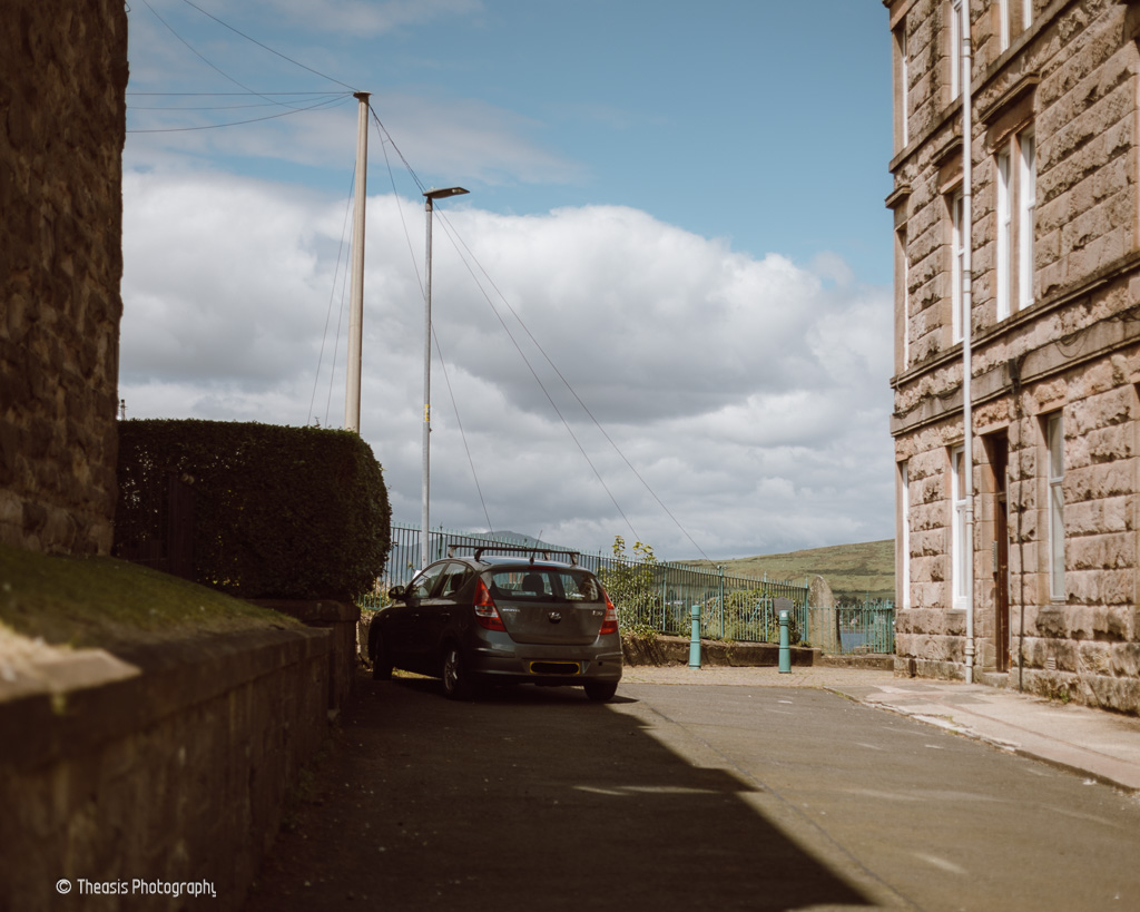 Road to the clifftop. The stone is just beyond the bollards.