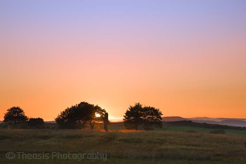 The sun sets behind the single remaining standing stone of Circle 3.
