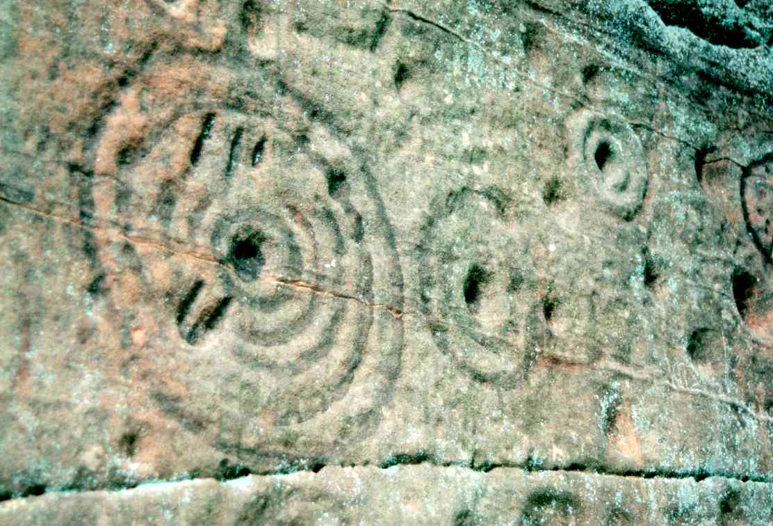  Close up of a cup mark with five rings and some additional linear marks.