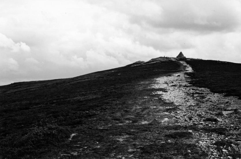 The path up Cairn Table.  At the top of the path is the pyramidal modern war monument.  Immediately to its left are the remains of one prehistoric cairn.  Left and behind is the second, largely intact, prehistoric cairn.