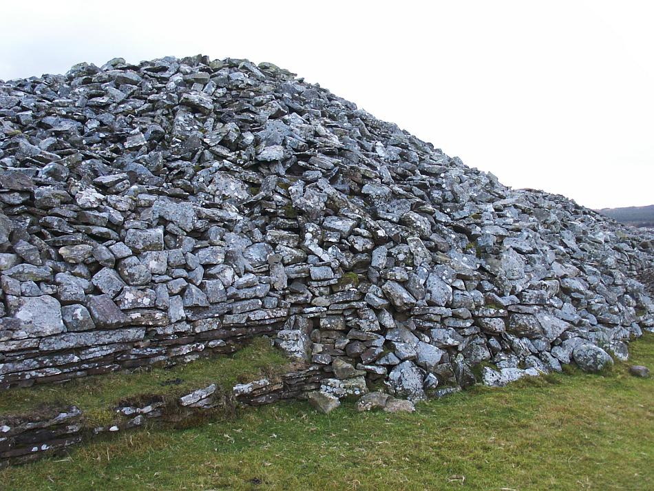 The remains of the southerly round cairn extend out from the later addition of the walls of the long cairn.
