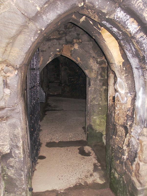 The sole entrance, in the north wall at the base of the northeast tower.  Ahead is the basement.  To the right are steps leading up to the great hall.  The original double door was designed such that opening the doors to the outside blocked access to the stairs.