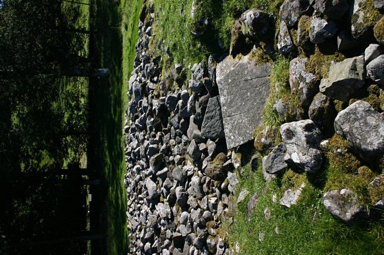 Looking east on the top of the cairn.  The large rectangular slab in the foreground is the capstone of a cist.