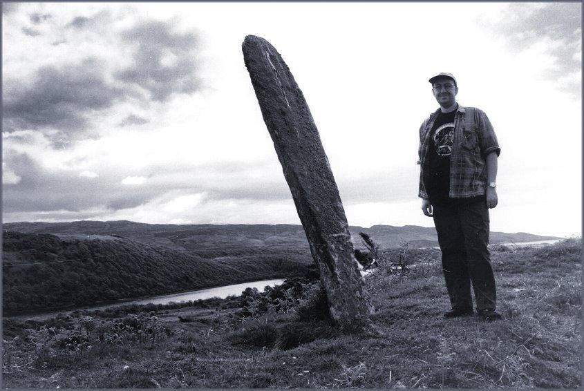 The yardstick is 5 feet 9 inches, the megalith would be a little over 7 feet tall if it didn't lean.