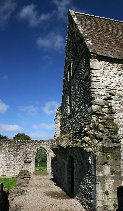 Looking north past the chapter house.  The root of the low arching roof over the covered walkway around the cloister can be seen projecting from the chapter house wall.
