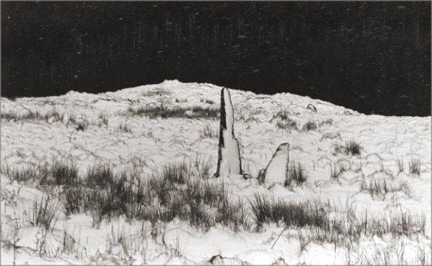 Looking east. The fallen stone lies under the snow immediately to the right of the two visible stones.