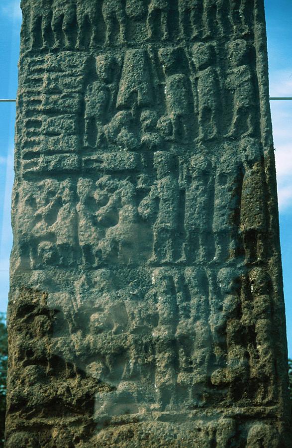 This lower-central panel shows, at top left, seven decapitatied bodieswith their executioner.  To the right are three figures who seem to be blowing instruments - perhaps carnyx, or battle-trumpets.  At top centre is a representation of perhaps a bell (is that a clapper below the notch?) or maybe a broch.