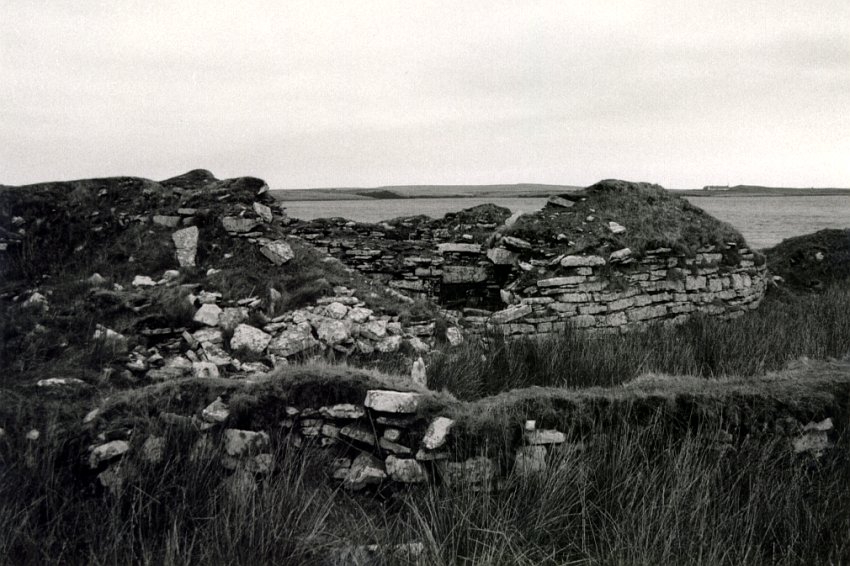 Looking north from the outbuildings.  There is much rubble to the left but a good line of wall curving away to the right.  The Loch of Yarrows is behind.